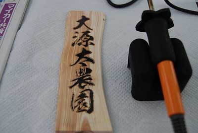 専用の電気ゴテで文字の外側をなぞり文字を切りぬきます。