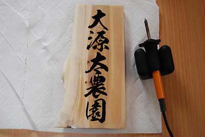 明のラベル用紙に大源太農園の文字を印刷してから表札に貼り付けます。