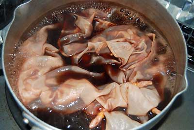 グラグラと煮立った桜染め液にハンカチを入れて染めます。