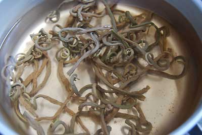 沸騰したお湯に干しゼンマイを入れて５分間茹でてから火を止めます。<br>