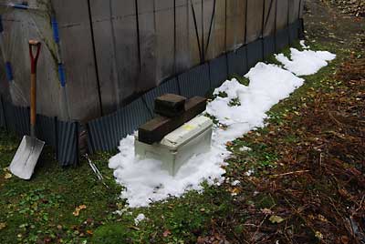 箱の廻りを気持ち雪で囲って重石をのせてセット完了しました。